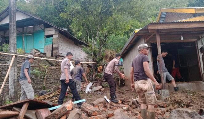 
 Anggota polisi dan warga sedang membersihkan rumah yang terkena longsor. (Doc: Mysr)